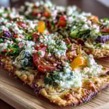 St. Patrick's Day Rainbow Veggie Flatbread Pizza with colorful vegetables arranged in a festive rainbow pattern on a crispy, cheesy base.