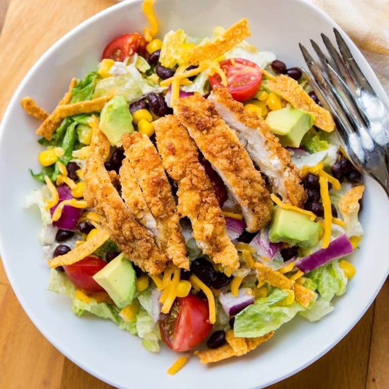 Crispy Chicken Taco Salad features crunchy tortilla strips, shredded cheddar, and a hearty Tex-Mex meal ready in 40 minutes.